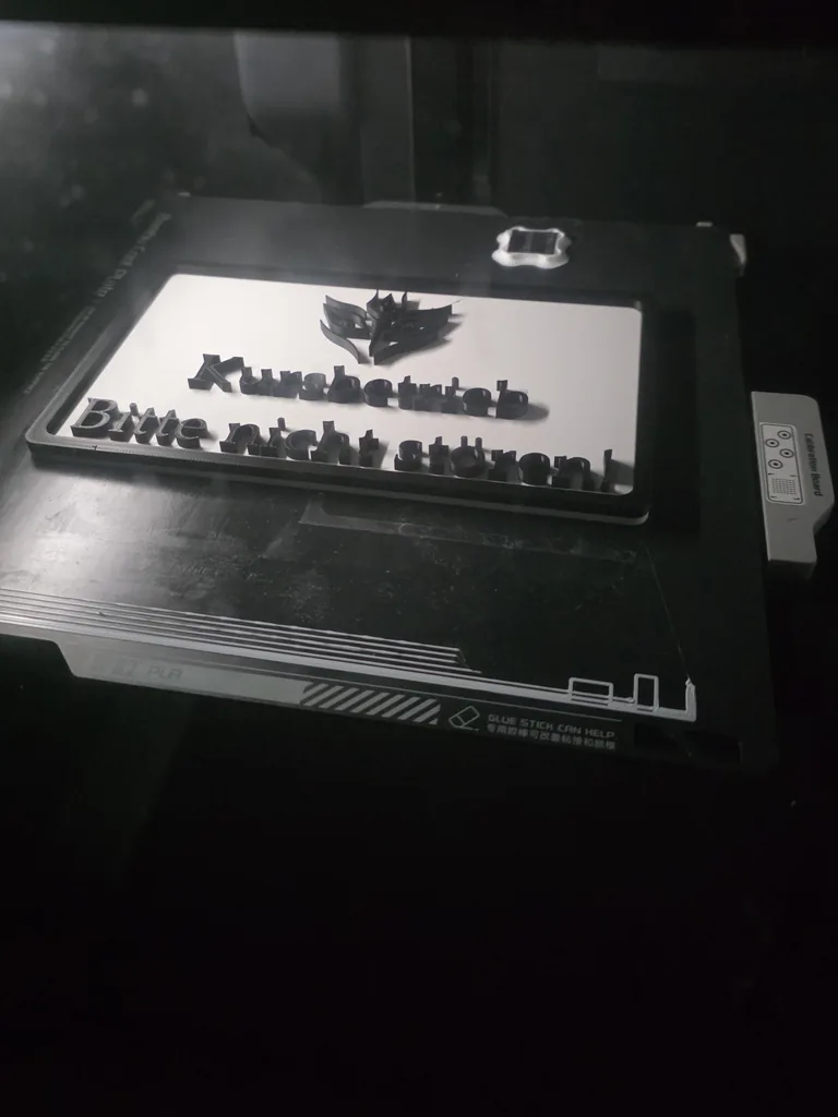 The sign on the build plate of the 3D printer right after printing