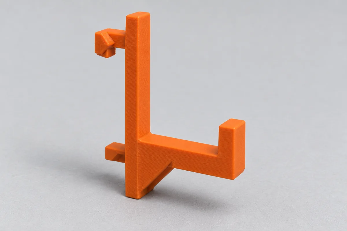 Orange printed pegboard hook with mounting peg, arm, gusset and lip on a light grey background