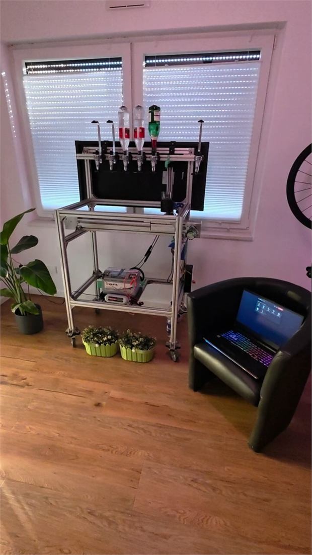 Cocktail machine built from aluminium profiles with bottle holders and pumps, a laptop in front of it.