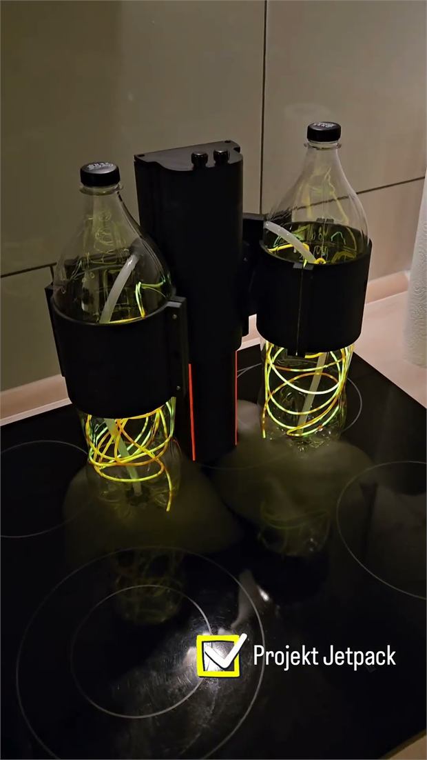Jetpack built from two bottles as tanks, wrapped in yellow glowing wire, with a black printed body between them.